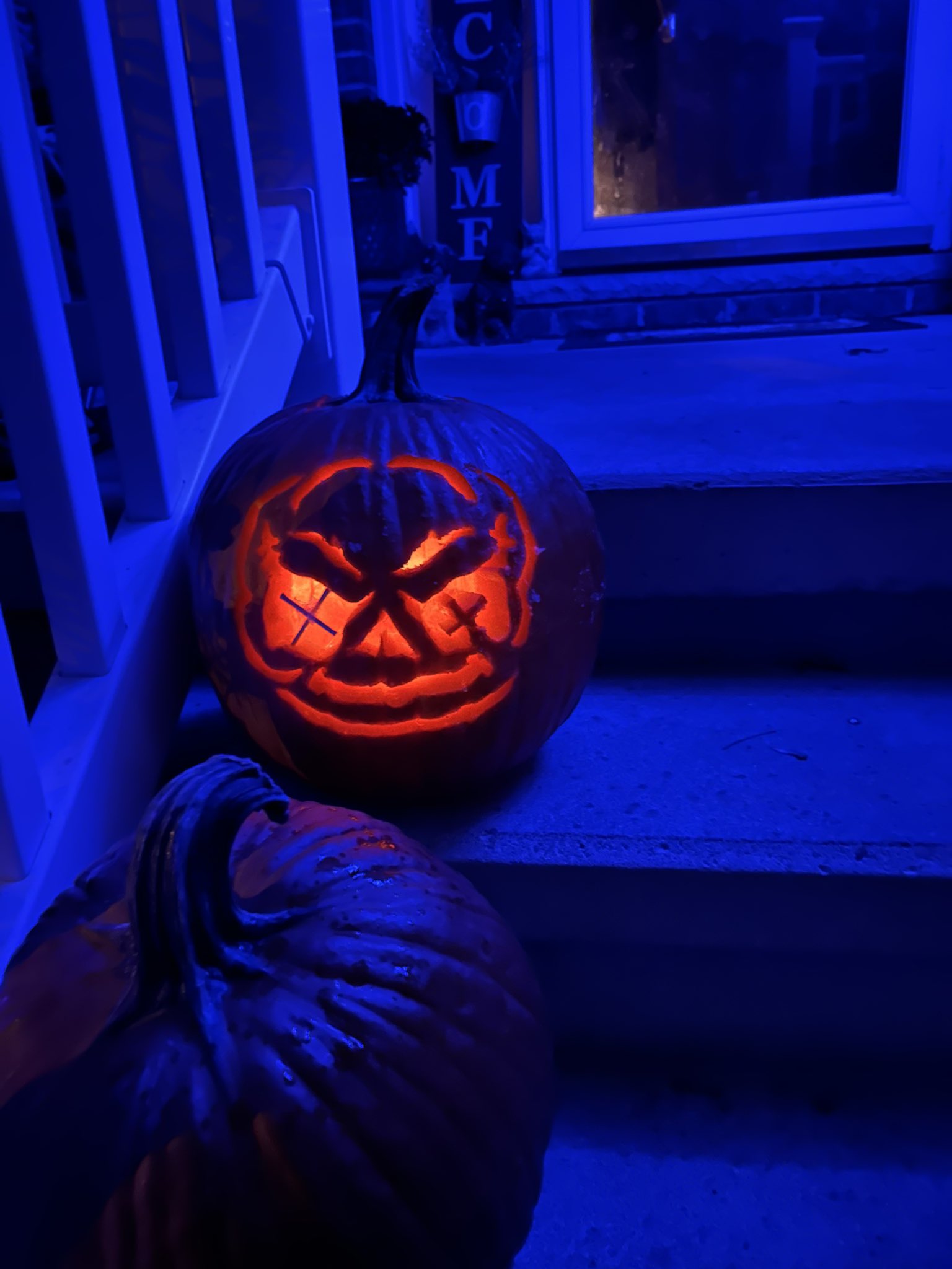 Chazz @StoneColdSteamr, winning pumpkin, Sam, carved, set on front doorstep stairs in the dark
